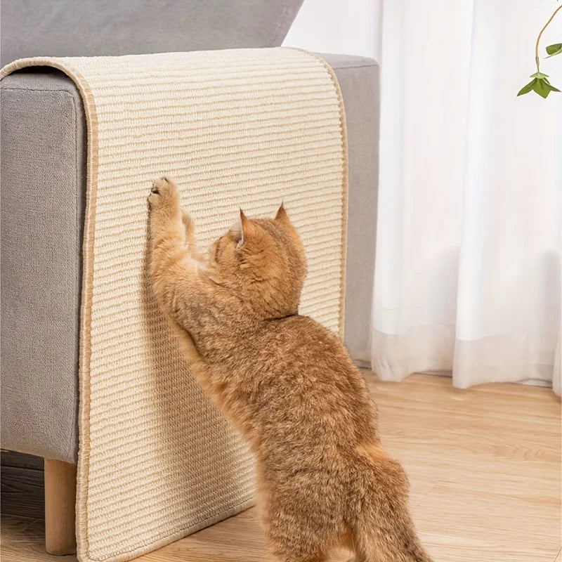 An orange tabby cat is scratching against a beige sisal cat scratching mat placed on a gray sofa.