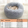 A gray fluffy pet bed shaped like a donut, suitable for small to medium pets.
