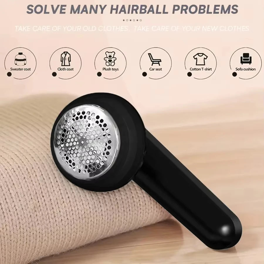A black portable electric lint and fabric shaver is shown resting on a beige cloth, with various clothing items displayed aro