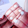 Close-up of a red plaid fabric harness featuring white buttons.