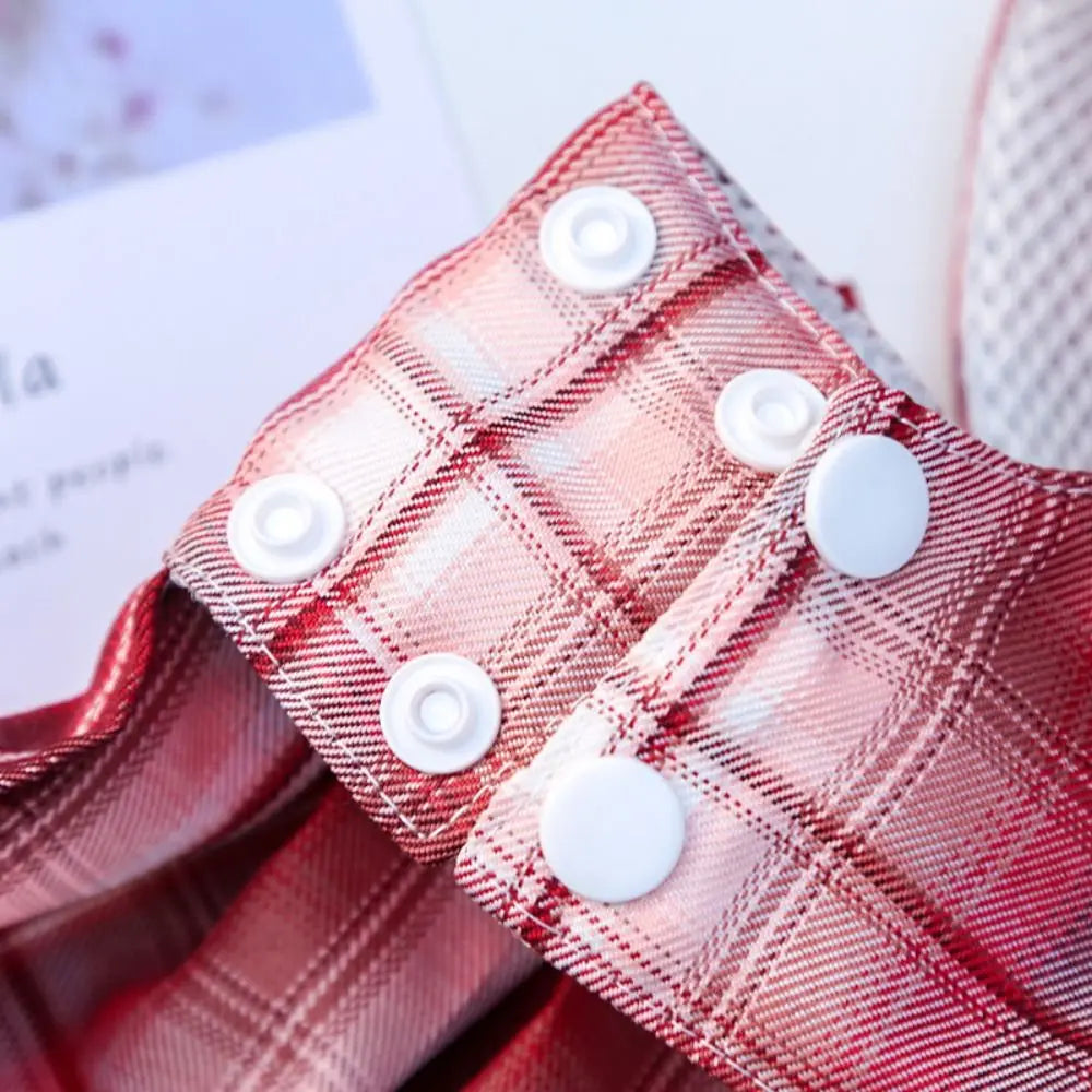 Close-up of a red plaid fabric harness featuring white buttons.
