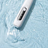 A white portable dog grooming trimmer is shown submerged in clear water.