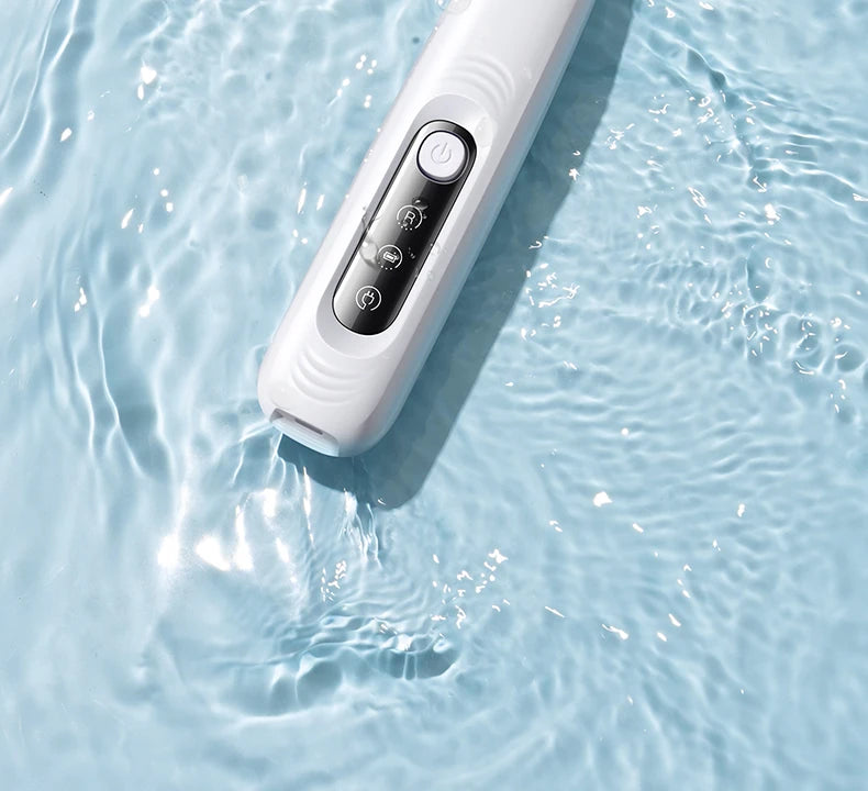 A white portable dog grooming trimmer is shown submerged in clear water.