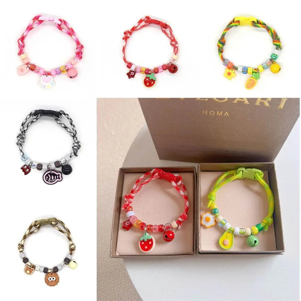 A collection of colorful braided pet collars with bells for cats and small dogs displayed in an open box.