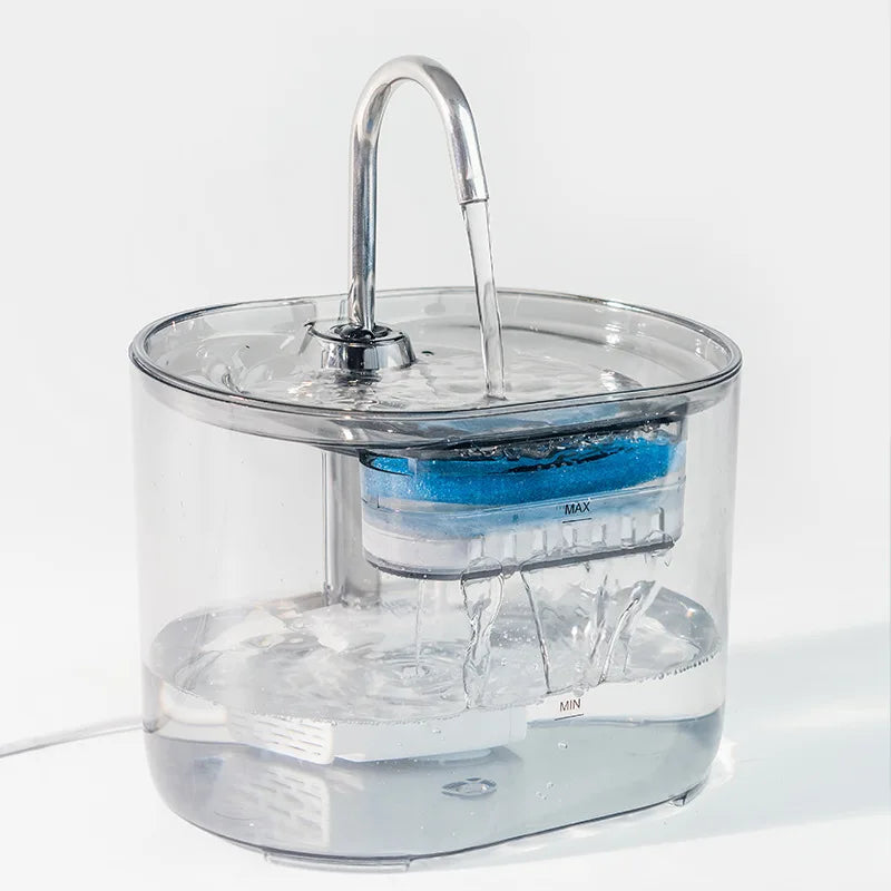 A clear water fountain with a stainless steel faucet and automatic sensor is shown operating in a glass container.