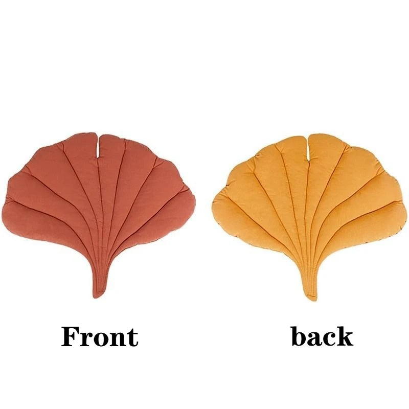 Front and back views of a reversible leaf-print pet cushion in terracotta and orange colors