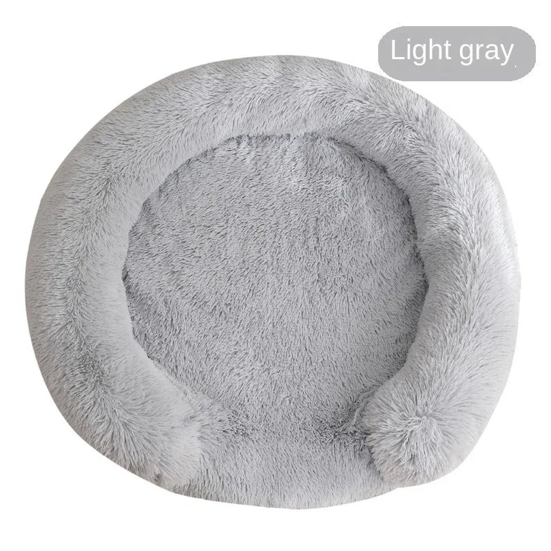A round, light gray, ultra-soft dog bed with a fluffy texture.