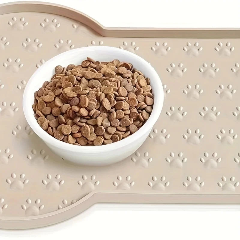 A white bowl filled with dry dog food rests on a beige non-slip silicone feeding mat.