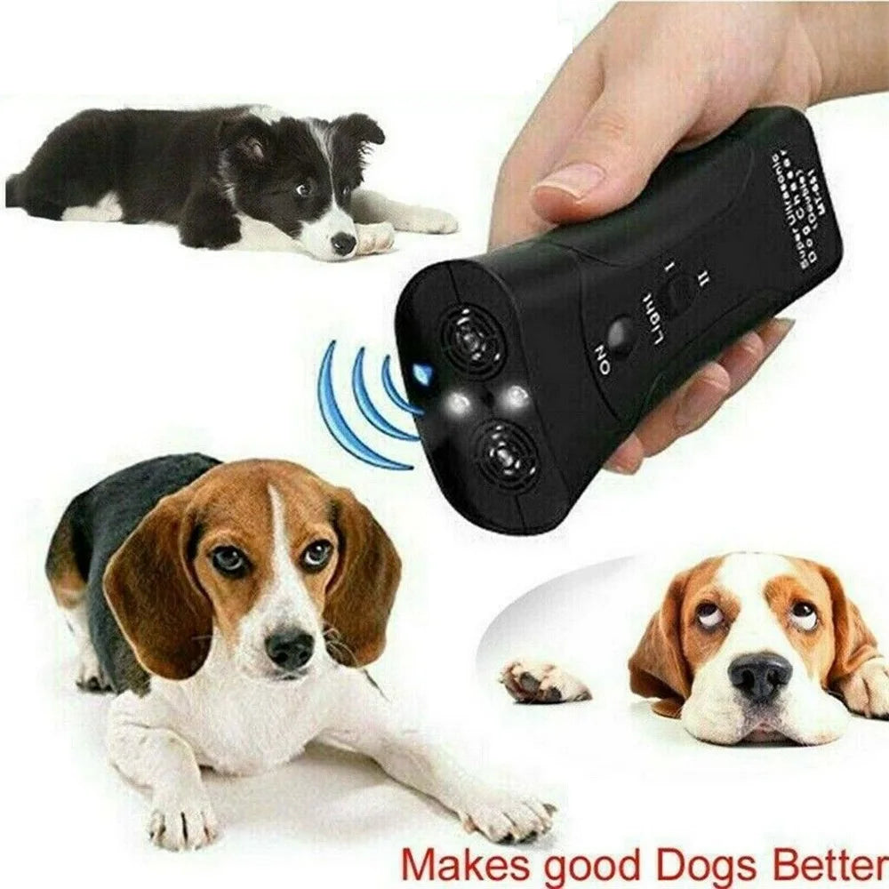 Una mano sostiene un dispositivo de disuasión de perros ultrasónico y láser negro, con perros visibles al fondo.