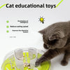 A gray cat is interacting with a green puzzle maze bowl designed for cat educational toys.