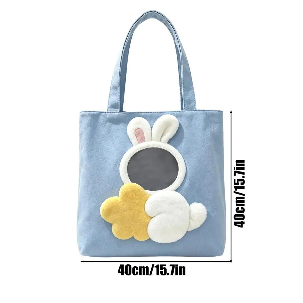 Light blue canvas pet carrier bag with a rabbit face design in yellow and white.