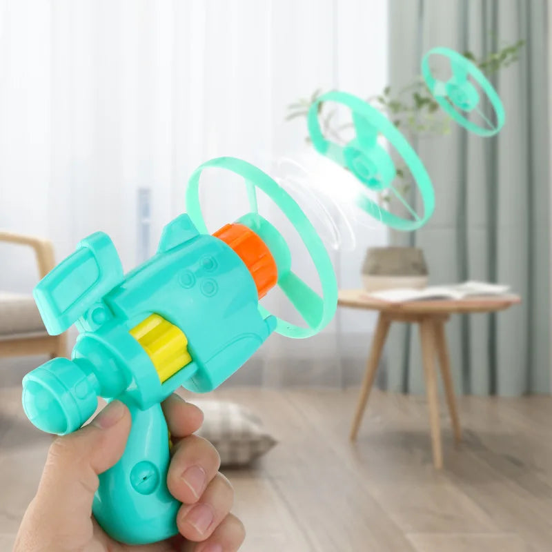 A hand holds a teal cat flying disc launcher toy set with four replacement discs, demonstrating the device's function.