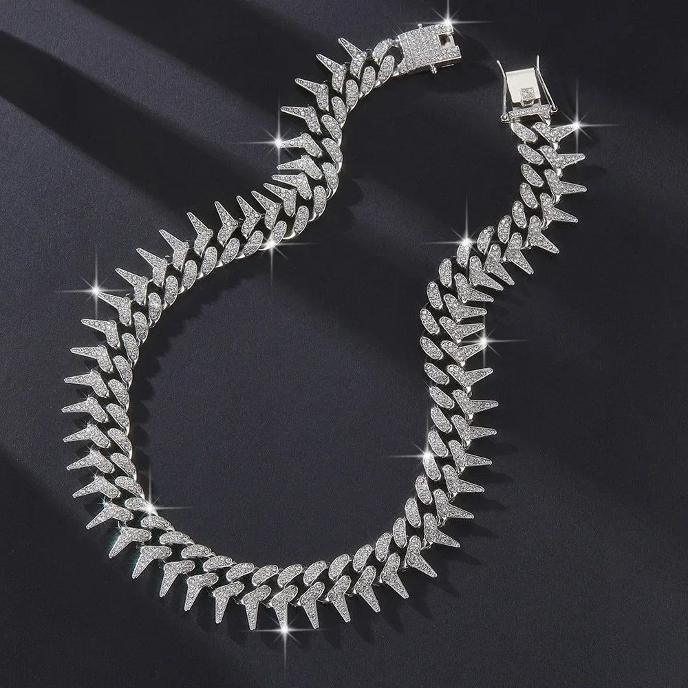 A close-up of a silver spiked Cuban chain bracelet adorned with diamond accents.