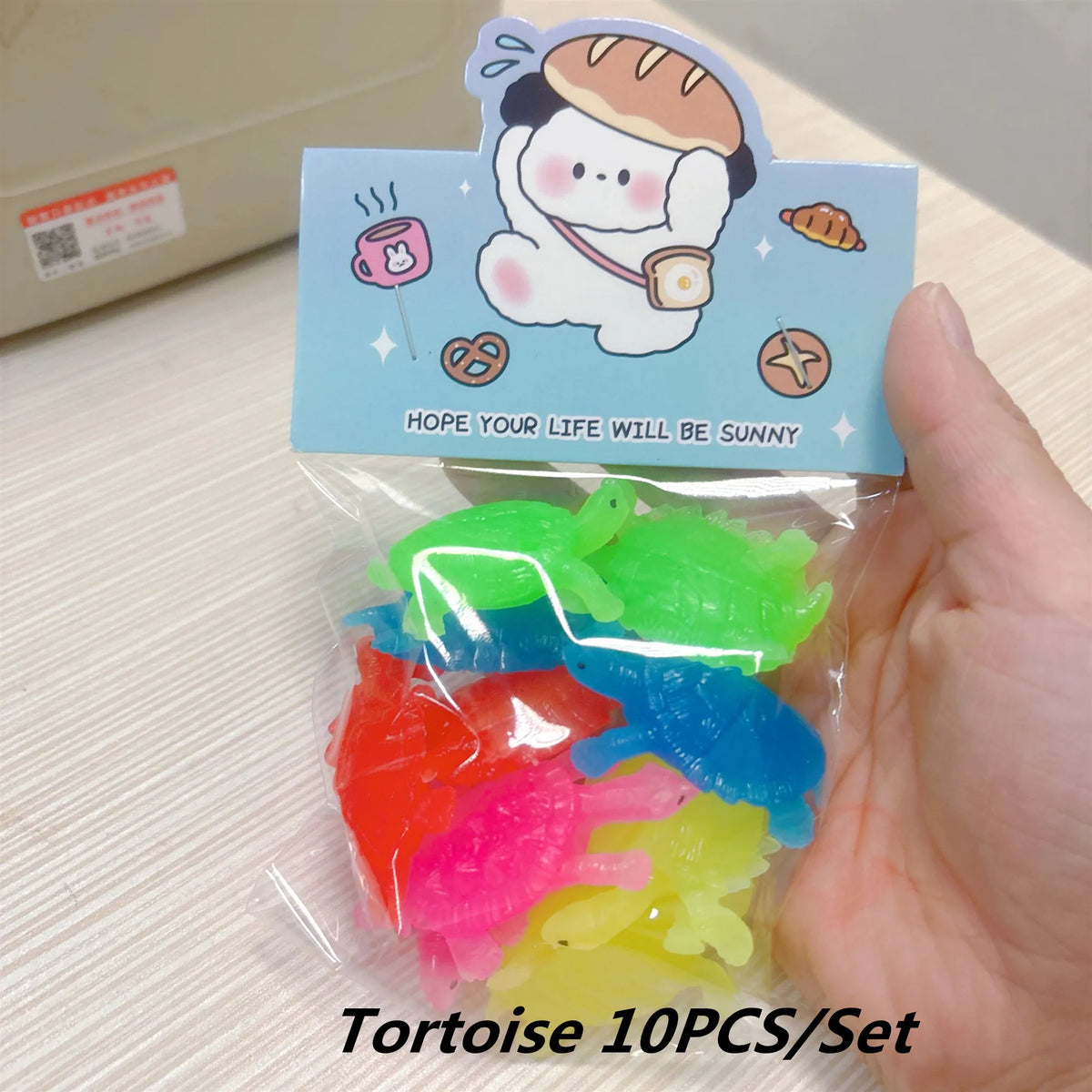 A clear plastic bag containing ten colorful soft rubber tortoise bath toys for kids.
