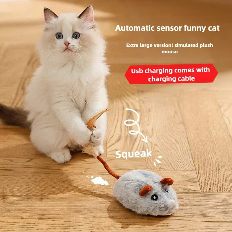 A fluffy white cat is interacting with a simulated plush mouse toy, which is connected to a USB charging cable.