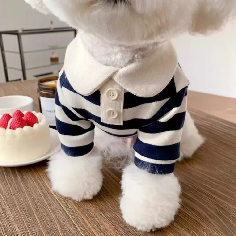 Ein flauschiger weißer Hund trägt eine marineblaue und weiße gestreifte Kühlweste.