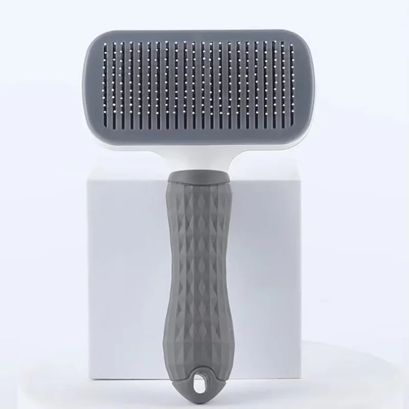 A gray pet slicker brush with a silicone head and handle is shown against a white background.
