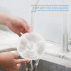 Hands rinse a white activated carbon filter thoroughly in cold water before use.