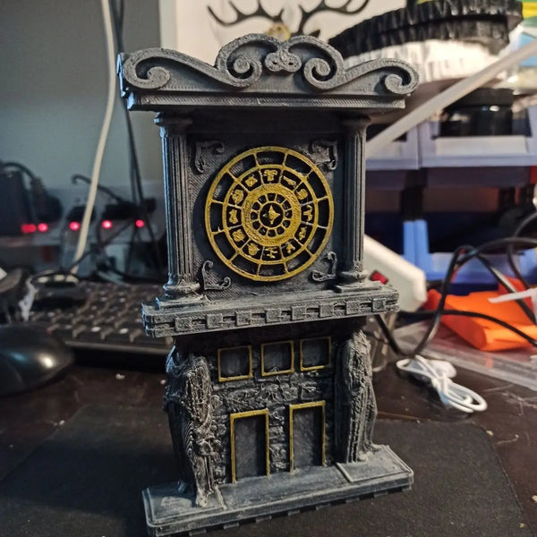 A dark gray 3D printed clock tower prop featuring a golden circular dial and architectural details.