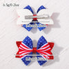 A pair of red, white, and blue star ribbon hair bows with metal clips shown against a white background.