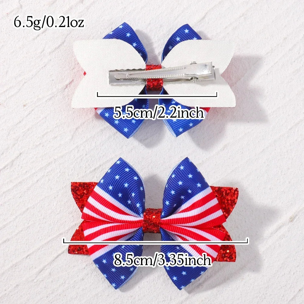 A pair of red, white, and blue star ribbon hair bows with metal clips shown against a white background.