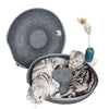 A gray cat bed with an open lid showing a striped tabby cat resting inside.