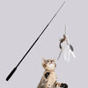 A tabby cat looks up at an extended telescopic cat teaser wand with a feather toy hanging above it.
