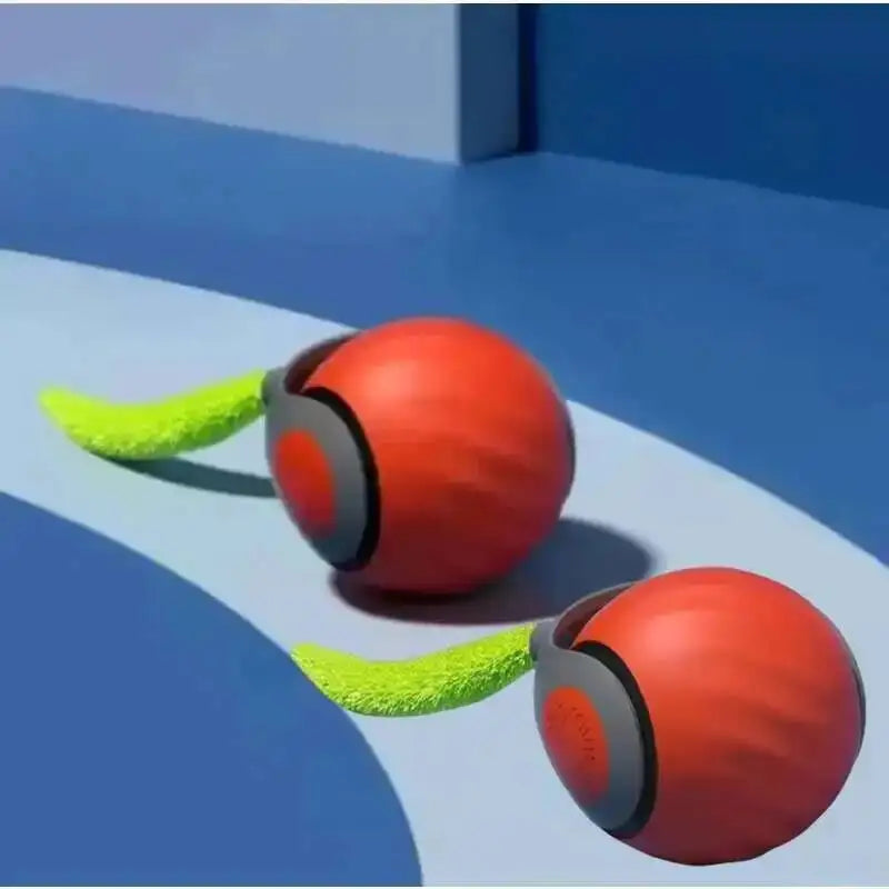 An orange spherical toy with a green faux tail is shown on a blue surface.