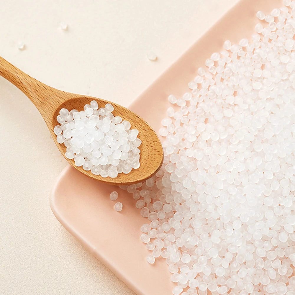White gel beads for a pet water fountain are shown on a wooden spoon and a pink dish.
