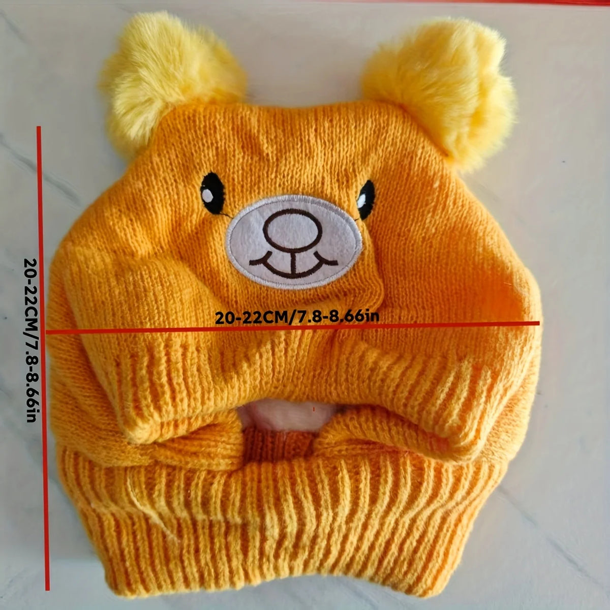 A knitted orange dog ear scarf and hat set featuring bear ears.