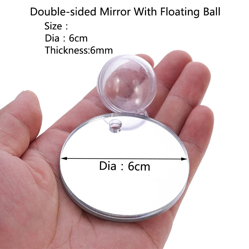 Double-sided mirror with a floating ball shown in a hand