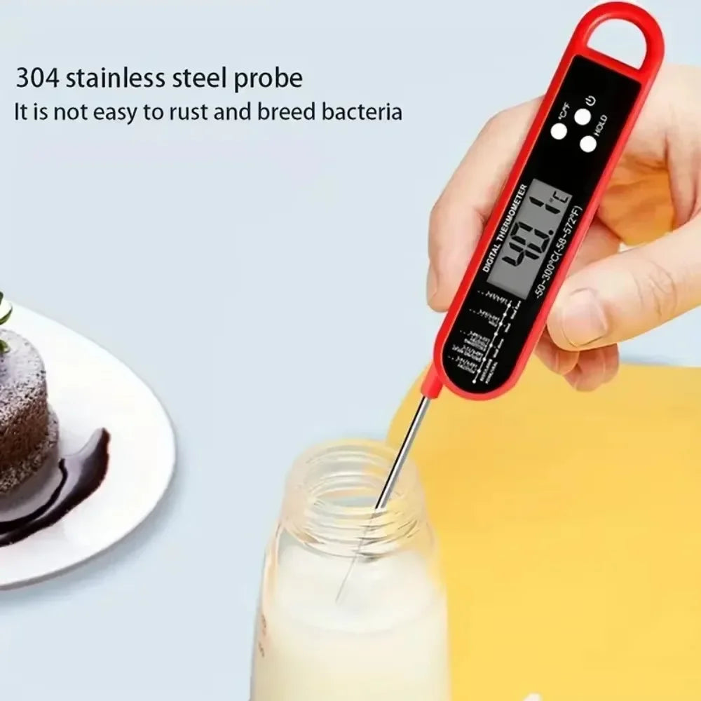 A hand holds a red digital meat thermometer with a probe inserted into a glass of milk.