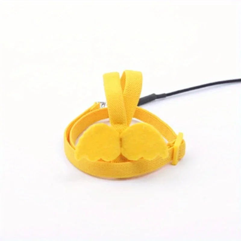Yellow fabric parrot flying harness with a black cord attached
