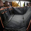 A view of a black quilted waterproof dog car seat cover hammock installed in the back seat of a vehicle.