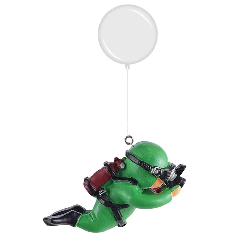 A green resin mini diver aquarium ornament with black and orange accents hanging from a white balloon.