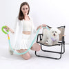 A woman is holding an adjustable hands-free dog leash with a green handle and a light blue cord, next to a white poodle.