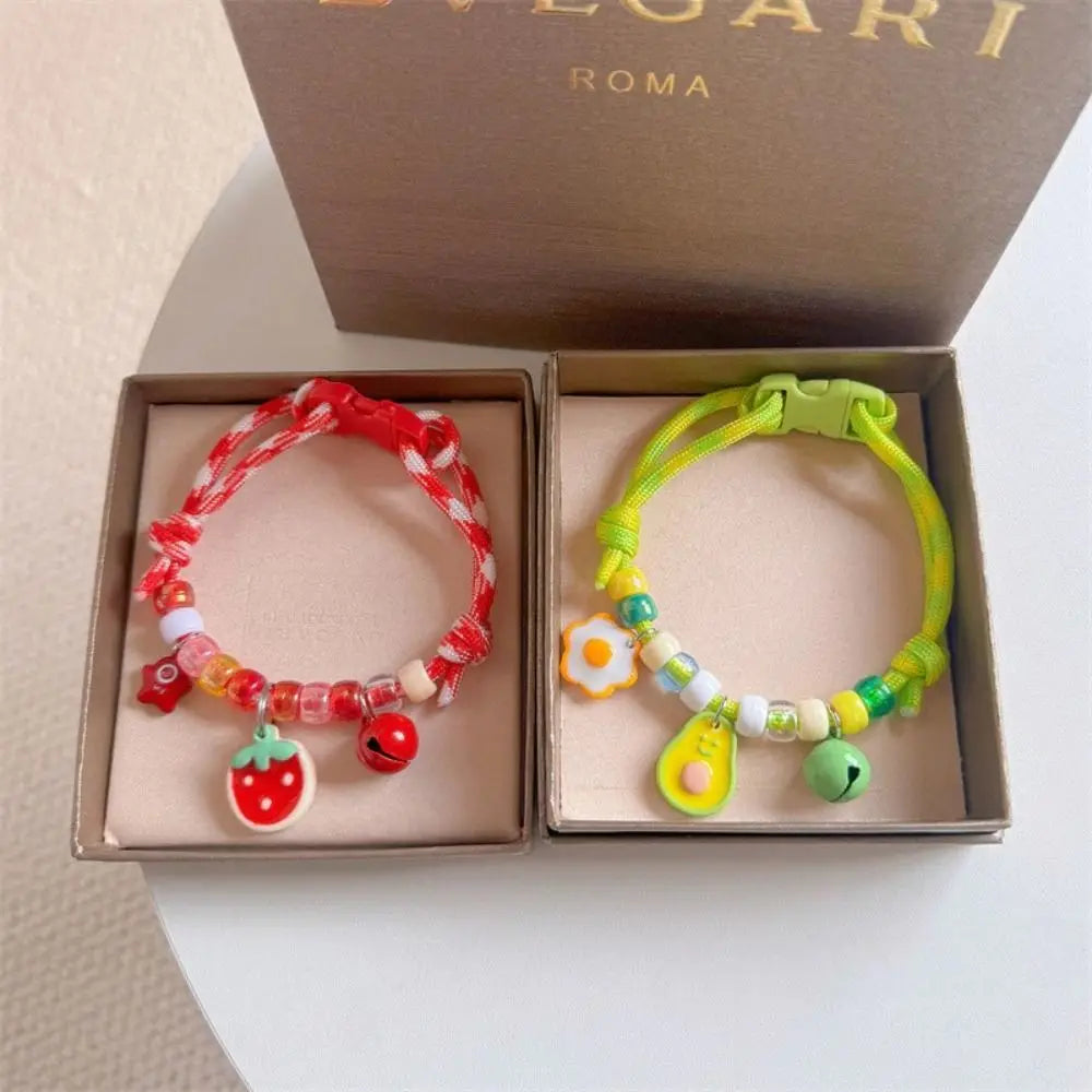 A set of colorful braided pet collars with bells for cats and small dogs displayed in a box.