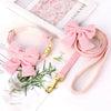 Pink velvet dog collar and leash set with a bowknot attached to a white background.
