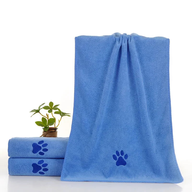 Ein Stapel blauer Mikrofaser-Haustierhandtücher mit Pfotenabdruck-Designs.
