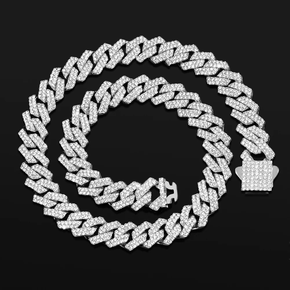 A silver iced out Cuban link chain necklace with rhombus diamond accents displayed against a black background.