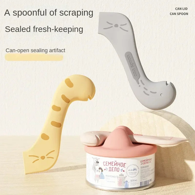 A light yellow pet feeding spoon with a can-opening sealing lid and a gray can spoon are shown.