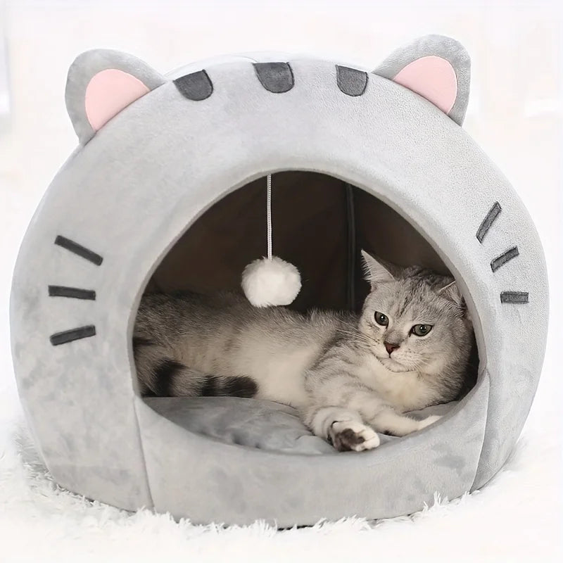 A gray plush cartoon cat cave bed with large ears and facial markings, featuring a cozy interior for a small pet.