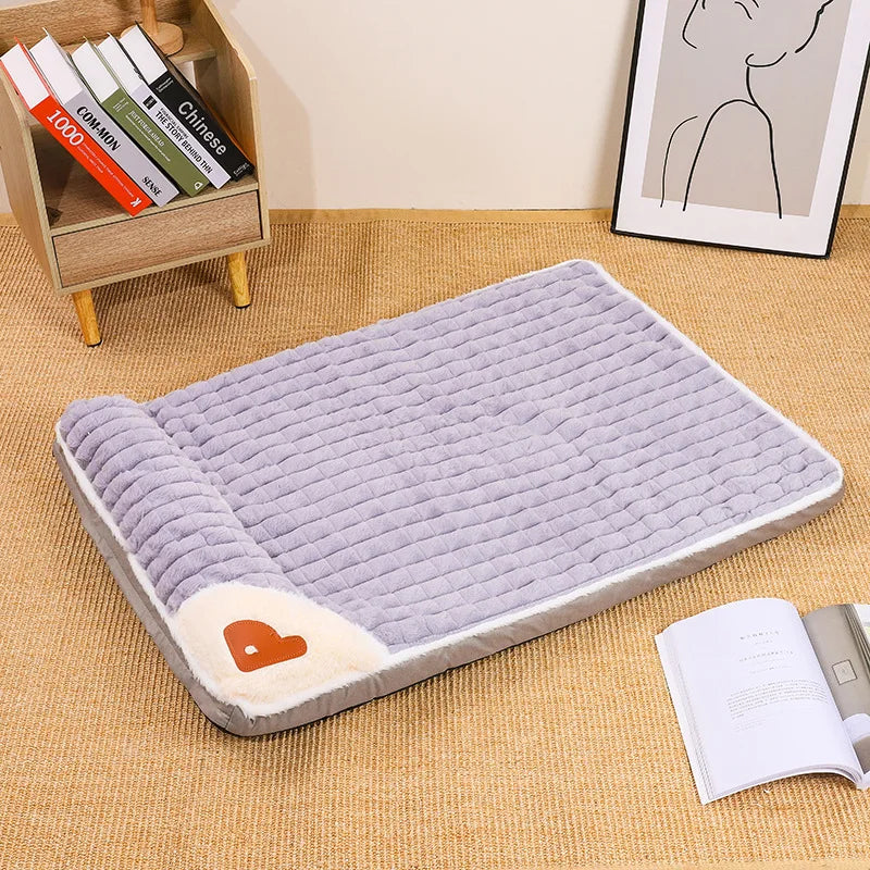 Un lit pour animal de compagnie rectangulaire violet avec housse amovible sur un tapis tissé à côté de livres et d'une impres