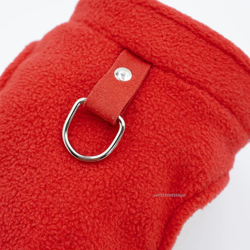 Primer plano de una chaqueta de forro polar roja brillante con un arnés de correa tipo D de cuero.