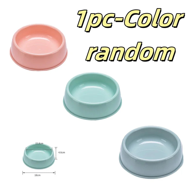 Three ceramic pet bowls in random colors and sizes, including a large pink bowl and two smaller teal bowls.