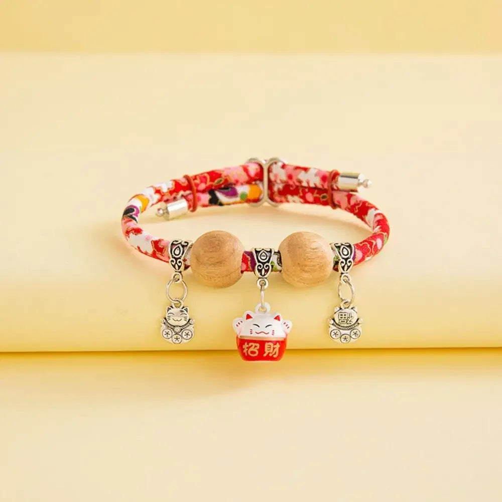 A natural camphor wood pet flea and tick collar with silver charms rests on a light yellow surface.