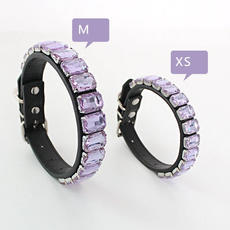 A pair of glittering rhinestone dog collars featuring crystal accents, shown with size markers M and XS.