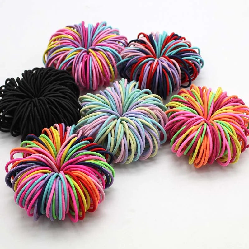 Colección de bandas elásticas para el pelo de niños en varios tonos de rosa, morado, naranja y negro.