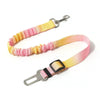 A pink and yellow adjustable traction rope safety harness with a metal clip and strap.