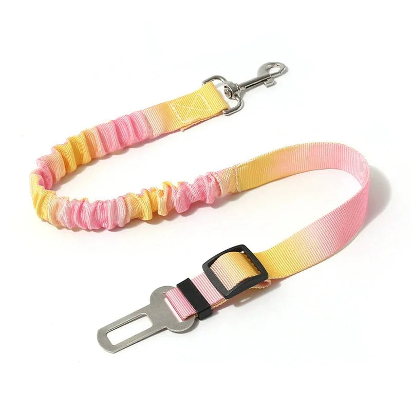 A pink and yellow adjustable traction rope safety harness with a metal clip and strap.